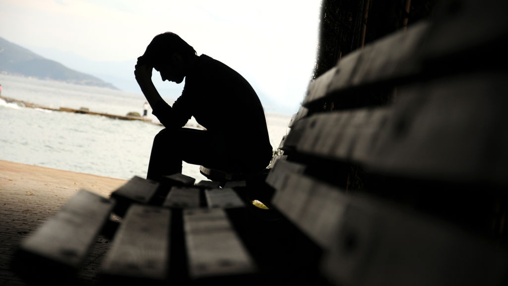 depressed young man sitting on the bench